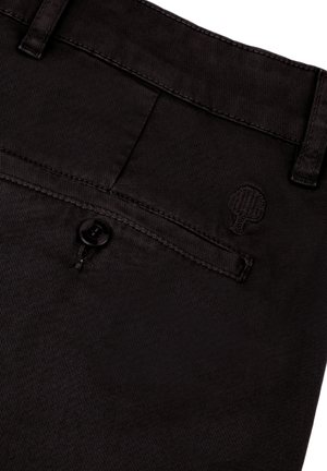 Pantalons en denim noir comprenant une poche arrière avec un bouton et un logo d'arbre brodé. Texture lisse avec des détails de couture raffinés.