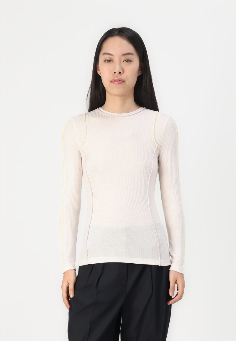 Beige Langarm-Rippoberteil mit kontrastierenden gelben und rosa Nähten. Slim Fit, runder Ausschnitt und elastischer Stoff.