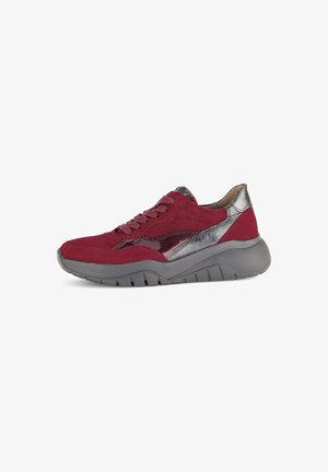 Red suede sneaker with silver accents and a textured grey sole. Features a lace-up front and a sleek, rounded design.