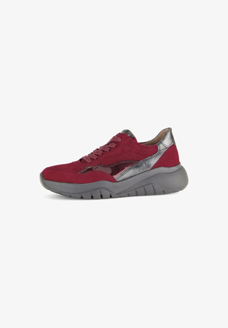 Red suede sneaker with silver accents and a textured grey sole. Features a lace-up front and a sleek, rounded design.