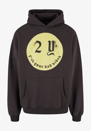 Sudadera con capucha de color gris oscuro que presenta un gran gráfico circular amarillo con texto negro. Tiene un bolsillo frontal y puños y dobladillo de canalé.