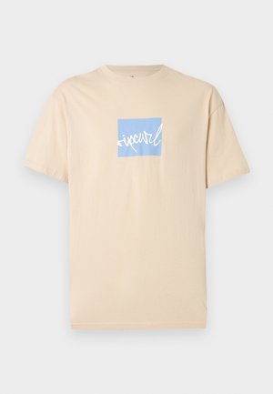 Beige T-skjorte med korte ermer, med en blå firkant og hvit skrift i midten av brystet.