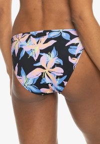 Costume da bagno inferiore floreale con uno sfondo nero e grandi motivi di gigli rosa e blu. Tessuto morbido e stretchy con una vestibilità di copertura media.