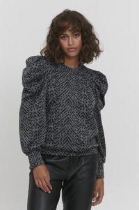 Grå sweater med puffede ærmer, der har et geometrisk mønster i en mørkere grå farve. Materialet ser tekstureret ud, med en rund halsudskæring.