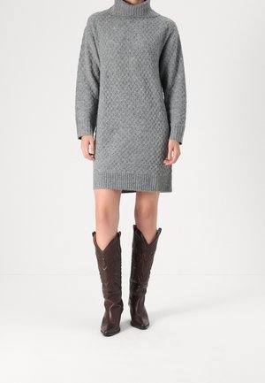 Gray knitted sweater dress with a turtle neck and diamond pattern, paired with brown leather cowboy boots featuring decorative stitching.