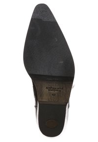 Suela de zapato de goma negra con superficie texturizada, con punta redondeada y un ligero tacón; incluye marca cerca de la zona del tacón.