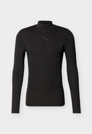 Sort atletisk langærmet trøje med høj hals og diskret Puma-logo på brystet, vist mod en ensfarvet hvid baggrund.
