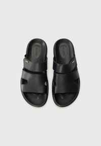 Black slide sandals with two textured straps, open toe design, and rubber sole. Features small cutouts for airflow and a logo detail.