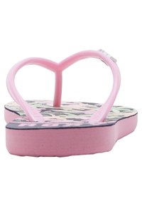 Lyserød flip-flop med en hjerteformet rem, der har et blomsterdesign på en mørk baggrund og en struktureret lyserød sål.