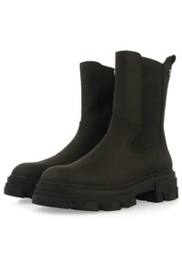 Botines negros con suela de goma gruesa, paneles laterales elásticos, acabado suave y un sutil detalle de costura para un aspecto elegante.