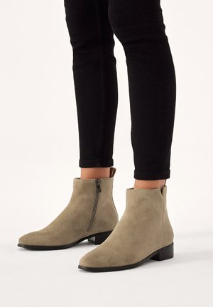 Suede ankle boots in light gray with a side zipper and low block heel, featuring a smooth texture and a rounded toe design.