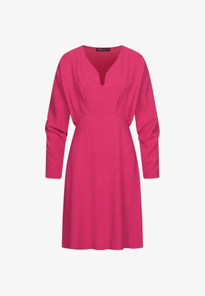 Fuksiaan pinkki mekko, jossa on V-aukko, pitkät hihat ja vyötärö sekä vyötäröaukko. Valmistettu pehmeästä, teksturoidusta kankaasta, pituus polven alle.