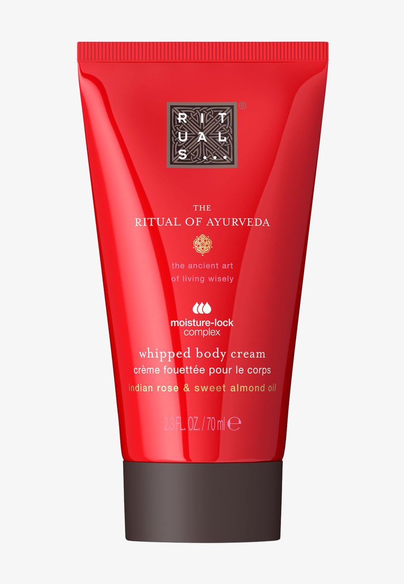 Tube compressible rouge de crème corporelle fouettée avec un capuchon brun foncé. Présente un logo et un texte en relief mettant en valeur la rose indienne et l'huile d'amande douce.