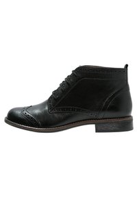 Botas de cuero negro hasta el tobillo con puntera redonda, diseño con cordones, detalles de brogue y un tacón bajo y apilado. Textura suave con un grano sutil.