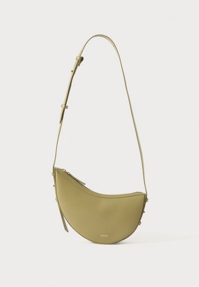 Sac à épaule en cuir vert avec une forme arrondie, une bandoulière réglable et une fermeture éclair, arborant des éléments en métal doré et un branding minimaliste.