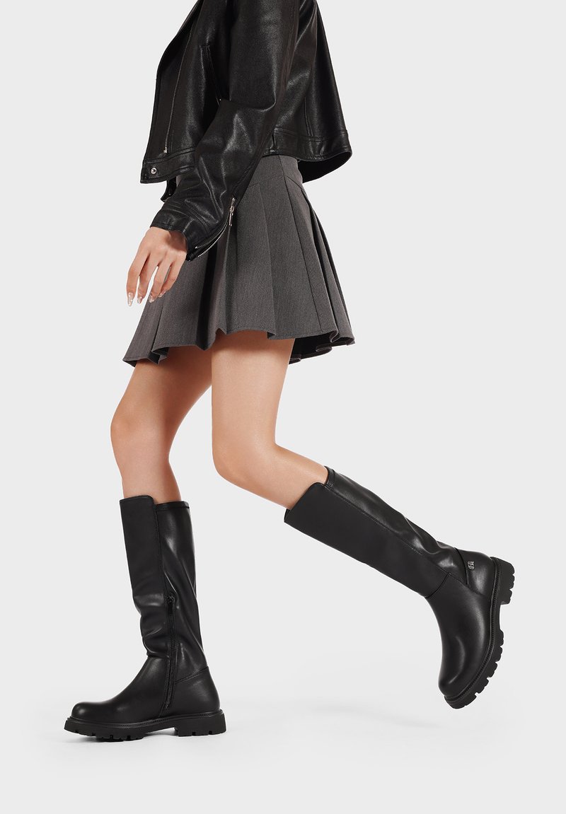 Stivali alti neri in pelle con una finitura testurizzata, dotati di una cerniera laterale e suole in gomma spessa per una buona aderenza.