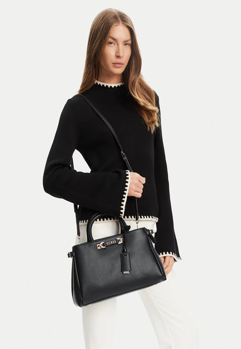Borsa a mano nera strutturata con doppio manico superiore, tracolla regolabile, accessori in oro e etichetta staccabile. Texture in pelle liscia.