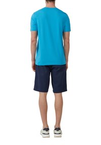 Blauwe T-shirt met korte mouwen van katoen, gecombineerd met marineblauwe shorts, gezien vanuit de achterkant, met een ronde hals en een casual pasvorm.