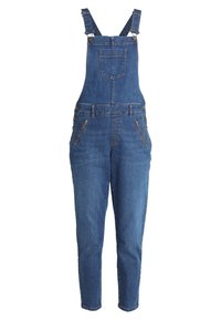 Denimoverall i blå tvätt, justerbara axelremmar och två framfickor med dragkedja. En overalldesign med en figursydd ben.