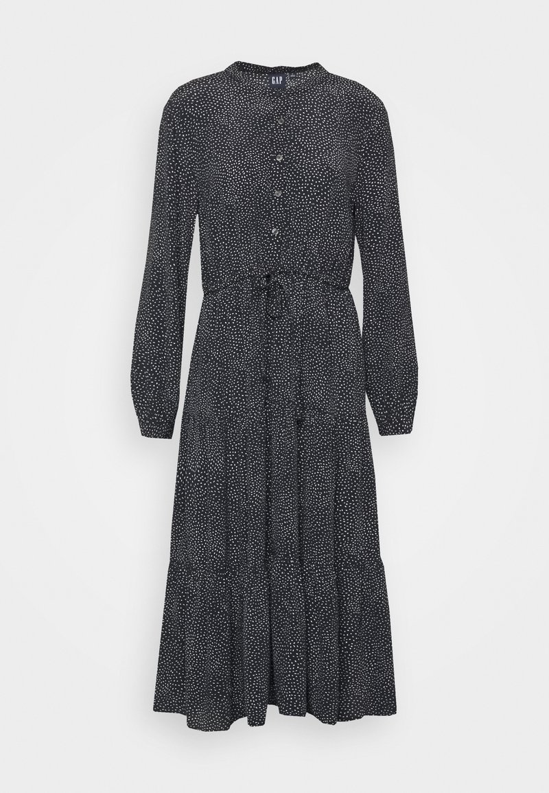 Schwarzes Langarmkleid mit weißen Polka-Punkten, geknöpftem Vorderteil, tailliertem Schnitt und gestuftem Rock. Hergestellt aus leichtem Stoff mit glatter Textur.