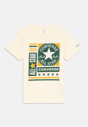 T-shirt creme com um gráfico impresso em verde e amarelo com "Converse", "Chuck Taylor" e um design de estrela. Mangas curtas e gola redonda.