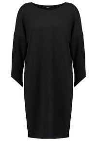 Robe noire surdimensionnée en tissu doux, avec un col rond et des manches larges. Design simple sans motifs ni accents visibles.