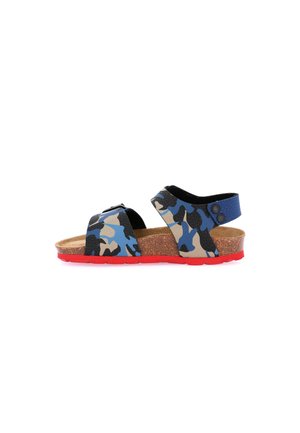 Sandalo per bambino con cinturini camouflage blu, neri e beige, sottopiede in sughero e suola rossa, su sfondo bianco.