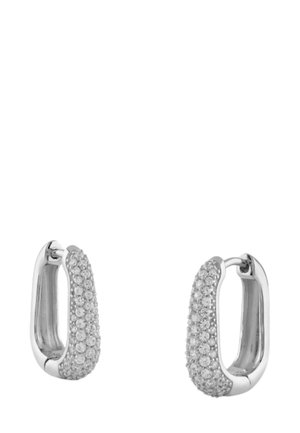 Boucles d'oreilles en argent en forme de créole avec un design texturé, ornées de petites pierres claires pour une touche d'éclat. La forme arrondie accentue la réflexion de la lumière.