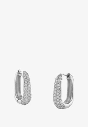 Boucles d'oreilles en argent en forme de créole avec un design texturé, ornées de petites pierres claires pour une touche d'éclat. La forme arrondie accentue la réflexion de la lumière.