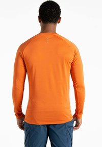 Langärmliges Sporthemd in leuchtendem Orange, aus glattem, leichtem Stoff gefertigt. Verfügt über reflektierende Akzente am hinteren Kragen.