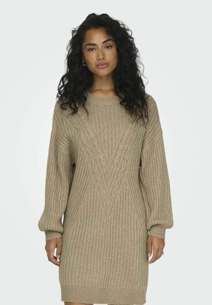 Vestido de suéter de punto beige con textura acanalada, que presenta patrones de trenzado en forma de V y mangas abullonadas. El dobladillo cae a mitad del muslo.