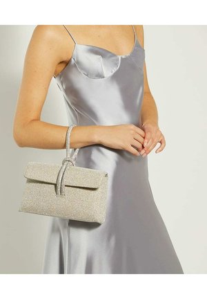 Pochette en argent scintillant avec un rabat repliable et une finition texturée. Elle possède une anse décorative. Portée avec une robe en satin argentée.