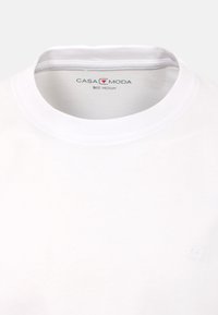 Vit bomulls t-shirt med rund hals, som har subtil branding, storleksetikett "CASA MODA," och slät textur. Storlek medium.