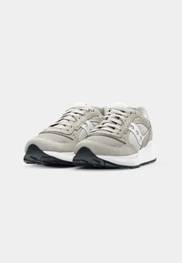 Light gray sneakers made of mesh and suede, featuring a white midsole, black outsole, and prominent logo details on the sides.