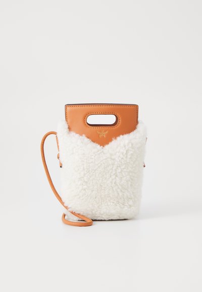 Pels og læder taske med en tan farvet toprem, hvid fluffy krop og en justerbar tan rem. V-formet design med glatte accenter.