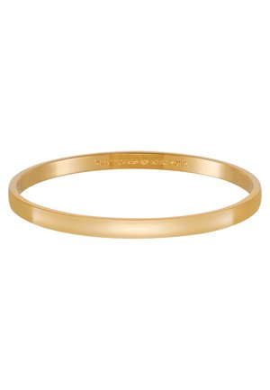 Bracciale bangle in tonalità oro con superficie liscia e lucidata. Presenta un design semplice ed elegante. Testo inciso all'interno: "kate spade NEW YORK."