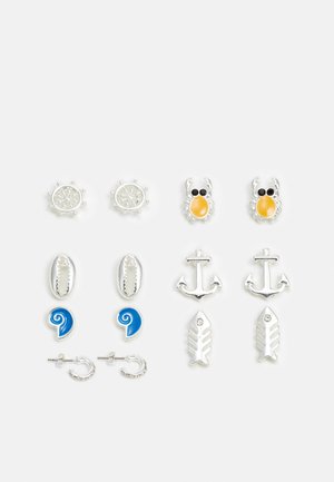 Conjunto de seis pares de pendientes de botón, que presentan diseños en tono plateado: acentos de cangrejo, timón, ancla, concha marina y pez, con detalles de esmalte azul y amarillo.