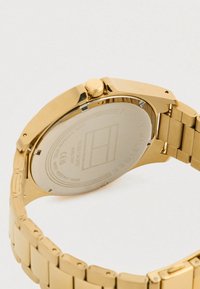 Gold metal wristwatch with stainless steel back, water resistant up to 3 bar, and a linked bracelet band.