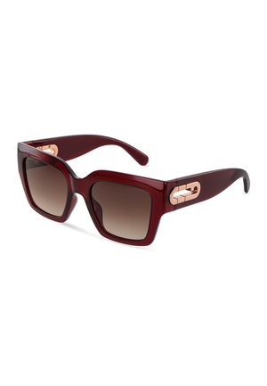 Lunettes de soleil carrées oversize rouge foncé avec verres marron dégradés et accents dorés sur les charnières des branches, sur fond blanc.