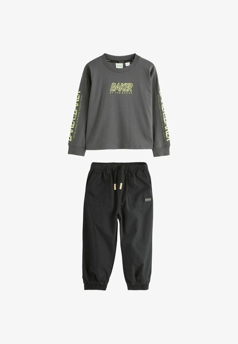 Tmavohnedá mikina s dlhým rukávom a žltým nápisom "Baker by Ted Baker" a čierne nohavice s elastickým pásom, šnurovaním v páse a prednými vreckami.