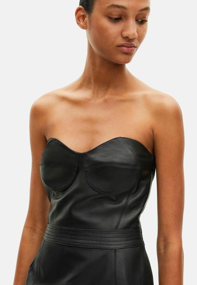 Robe noire sans bretelles en cuir avec un corsage ajusté doté de coutures de contour, une taille marquée et une texture lisse.