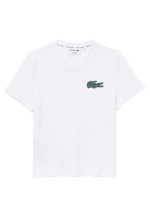 Biała koszulka z krótkim rękawem i okrągłym dekoltem, z małym zielonym haftowanym logo krokodyla na lewej piersi oraz metką marki wewnątrz kołnierza.