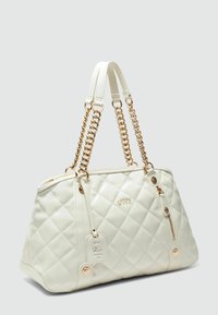 Sac à main blanc matelassé avec des accents en chaîne dorée, doté d'une poche zippée, d'une étiquette de signature et de deux poignées courtes pour le transport.