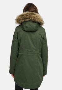 Parka verde con cappuccio in pelliccia sintetica, dotata di vita cintrata, maniche lunghe e tessuto liscio. La vista posteriore mostra i dettagli delle cuciture.