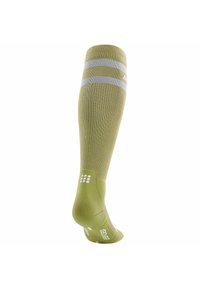 Calza compressiva fino al ginocchio di colore verde chiaro con strisce argento, texture a coste, tallone imbottito e motivo a punto sulla suola.