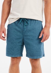 Herre shorts i teal lavet af letvægtsstof med elastisk talje og snor, med sidelommer og svingede kanter.