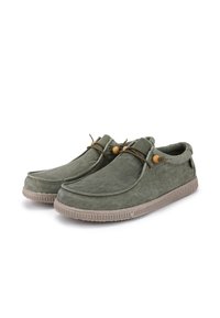 Green slip-on shoes with a textured fabric upper, features a contrasting beige rubber sole and leather lacing with wooden accents.