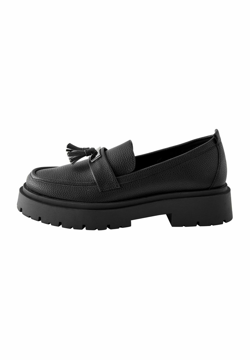 Mocassino in pelle nera con superficie testurizzata, dettaglio a frange frontali, suola in gomma nera robusta e tacco largo per un'altezza aggiuntiva.