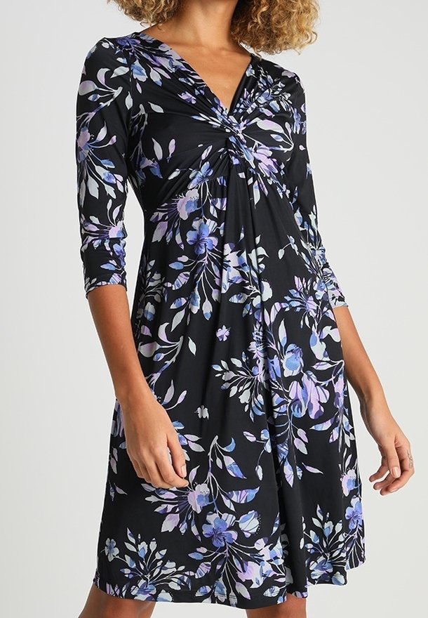 Robe noire avec un motif floral dans des tons violets et bleus. Dotée d'un décolleté en V, de manches trois-quarts et d'un design de corsage froncé.