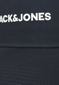Navy blue cap with a structured design, featuring a stitched band and the white text "BLACK&JONES" prominently displayed.